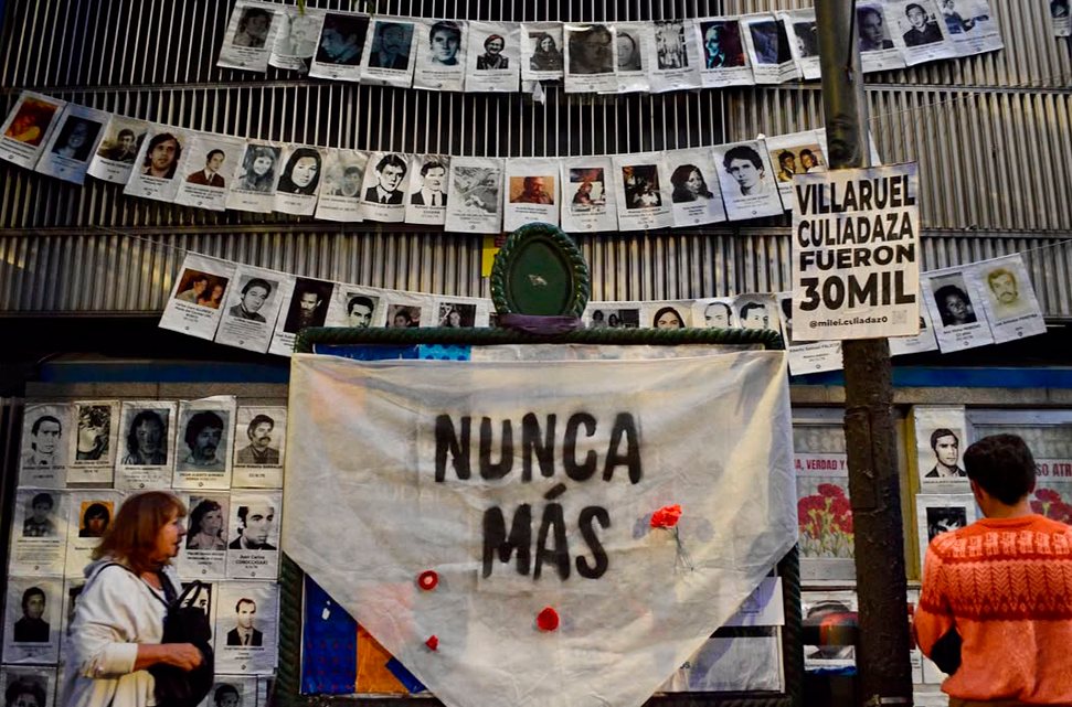 fachada-de-un-edificio-con-fotos-de-personas-desaparecidas-y-un-pañuelo-que-dice-Nunca-Mas