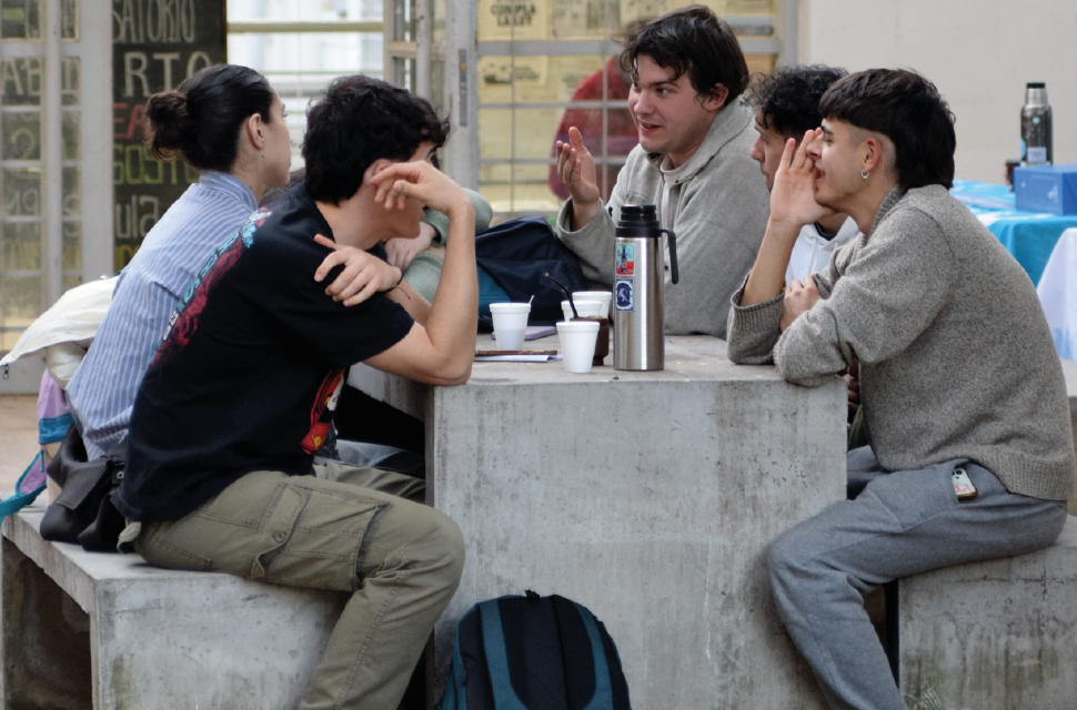 estudidantes-sentados-en-una-mesa-conversando