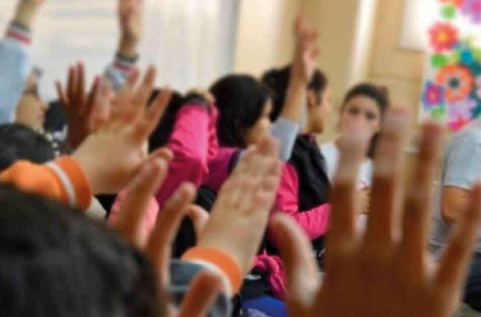 jovenes-en-un-aula-con-las-manos-levantadas
