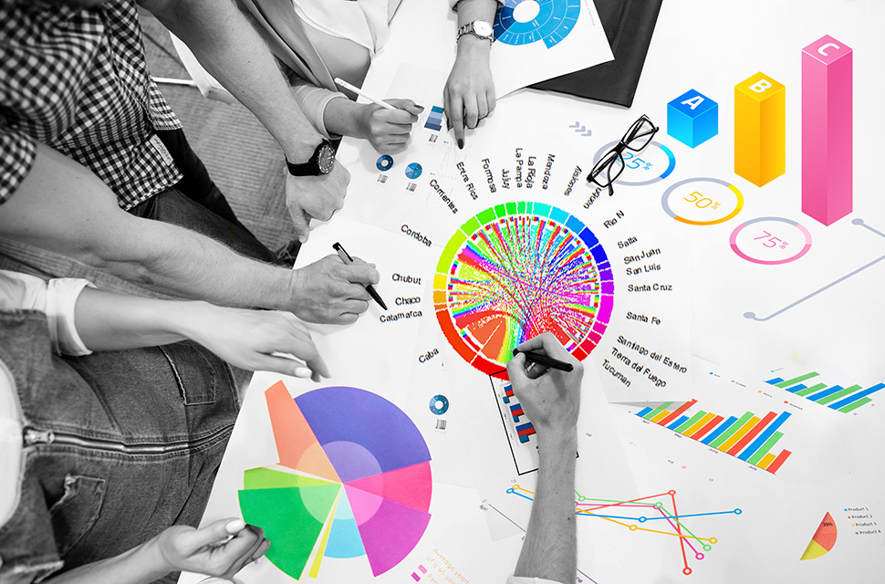 mesa-con-manos-trabajando-sobre-gráficos