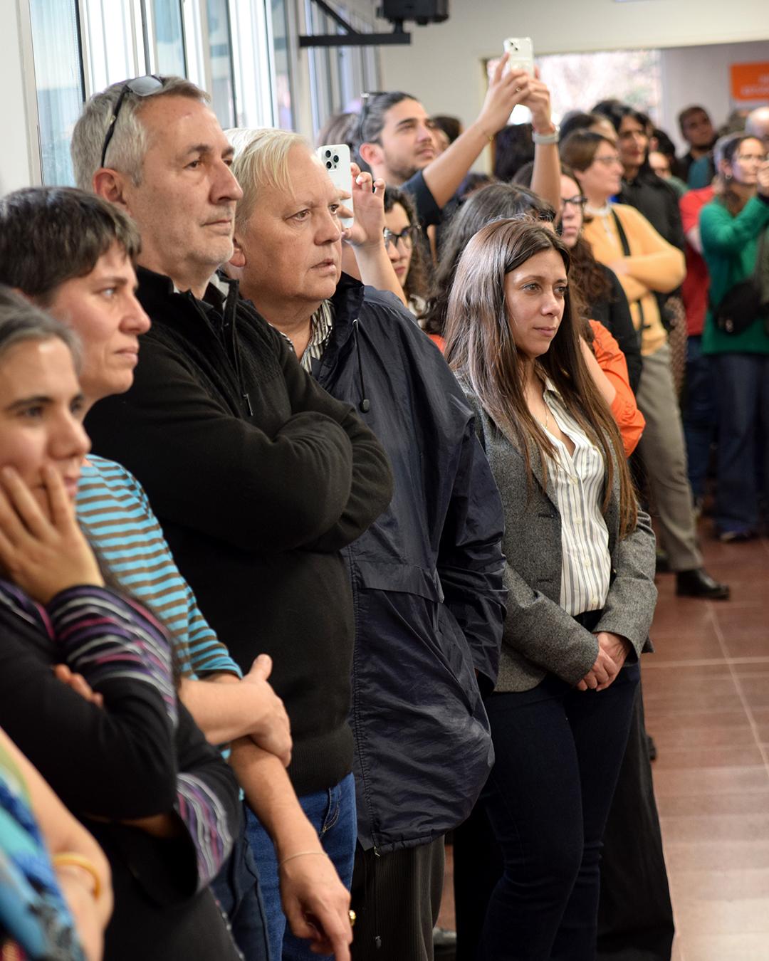 personas paradas mirando al escenario