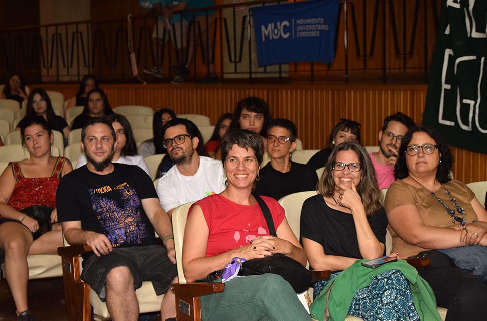 Docentes y público sentados y con gestor soriente mirando hacia el escenario