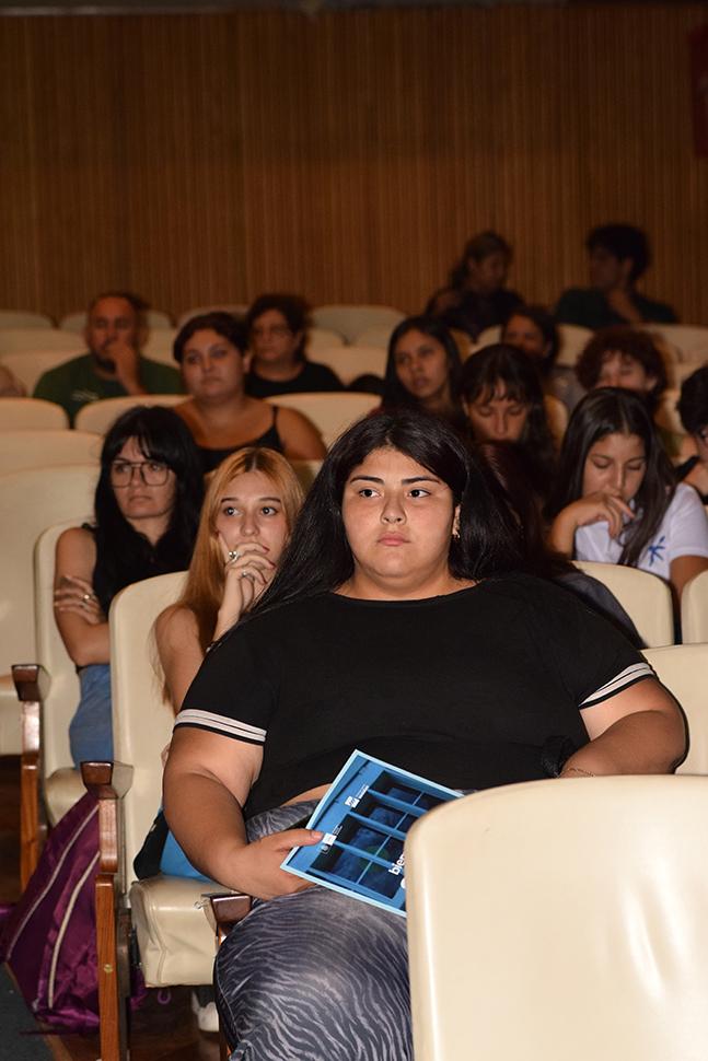 Jovenes ingresantes mirando al escenario con gesto de concentracion