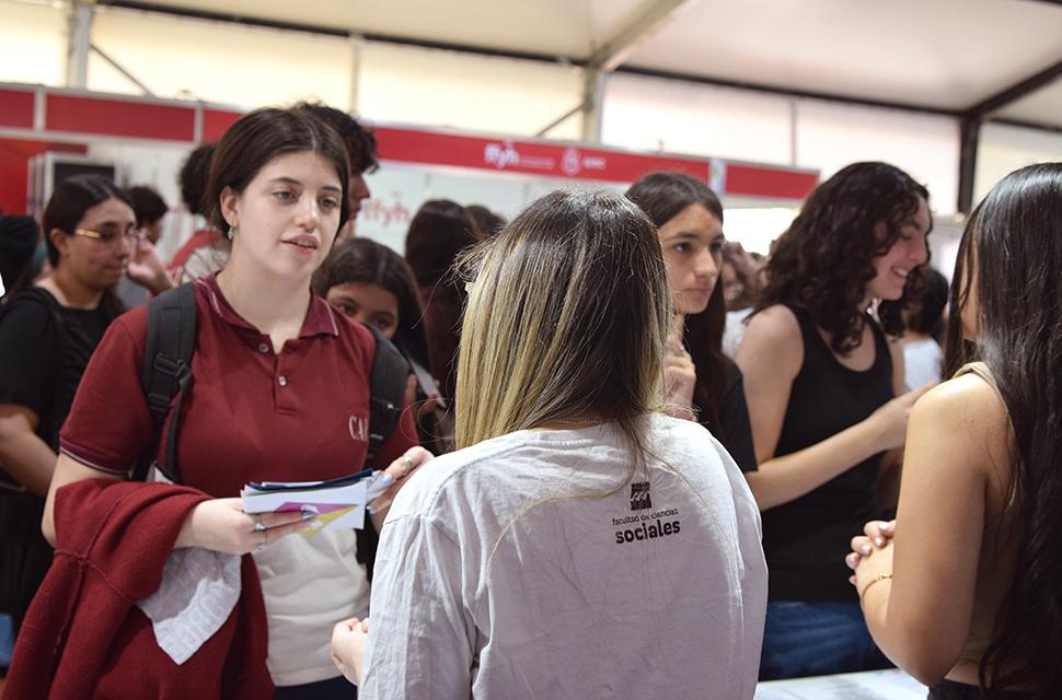estudiante de sociales de espalda conversando con estudiante de secundrario