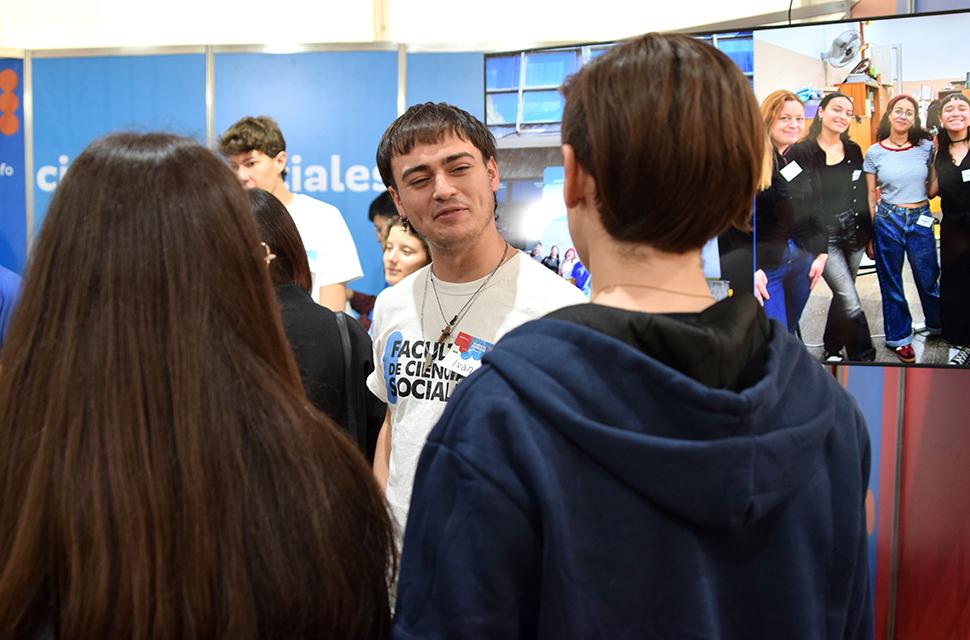 Estudiante de sociales conversando con estudiantes de secundario