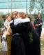 Abrazo entre la vicedecana saliente Jacinta Burijovich y la vicedecana entrante Liliana Córdoba. gente de fondo observndo el abrazo